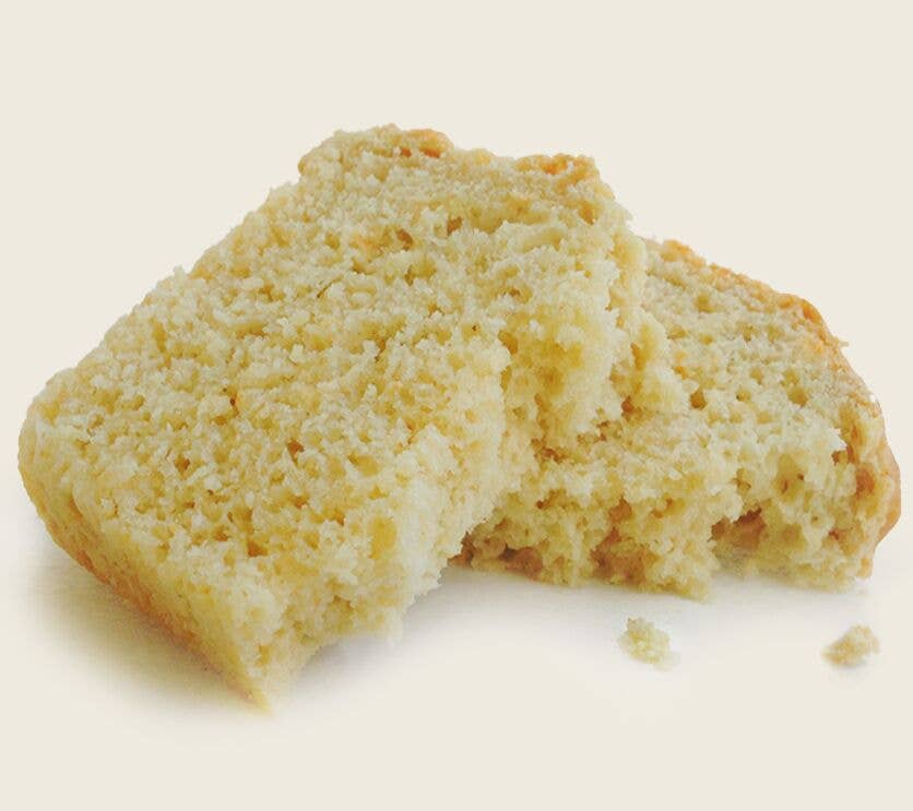 Loaf of bread with a bite taken out on a beige background