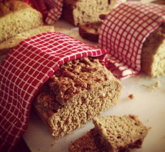 Loaf of bread with a red checkered cloth on a white surface