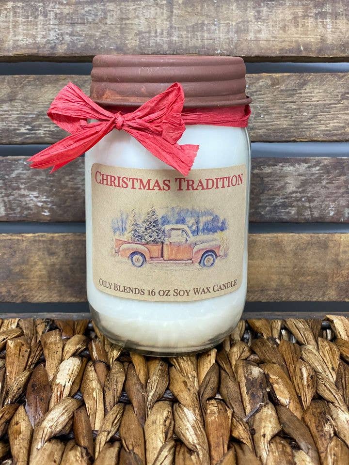 Candle jar labeled 'Christmas Tradition' with a red bow on a wooden surface.