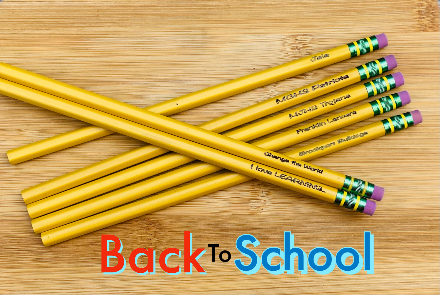 A pack of yellow Ticonderoga pencils with personalized engraving on each, placed on a wooden surface with the text 'Back to School' displayed.